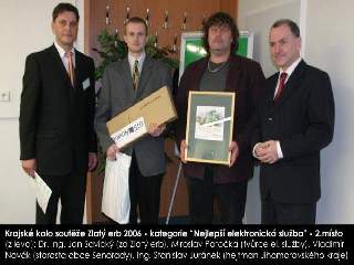 Fotografie předání ceny: (z leva) Dr. Ing. Jan Savický (za Zlatý erb), Miroslav Patočka (tvůrce el. služby), Vladimír Novák (starosta obce Senorady), Ing. Stanislav Juránek (hejtman Jihomoravského kraje)