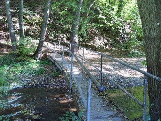 Narazíme na lávku přes říčku Chvojnici. Zde mohou zájemci odbočit doprava a prohlédnout si zříceninu hradu Kraví hora.