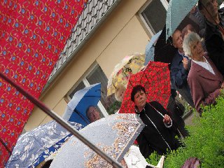 Většina průvodu se skryla pod deštníky..