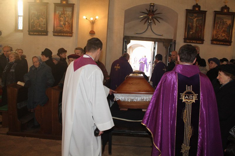 Bratři kněží vynášejí rakev otce Jana hlavním vchodem mohelského kostela: