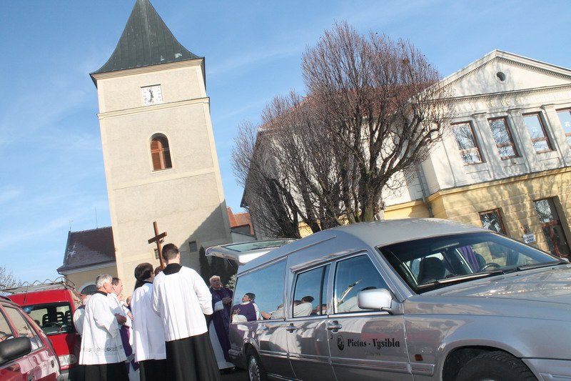 Před kostelem Všech Svatých v Mohelně a základní školou: